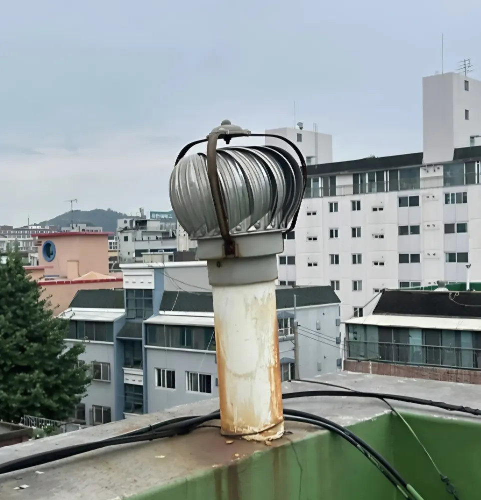 옥상 배관 위 설치된 회전 환풍기
